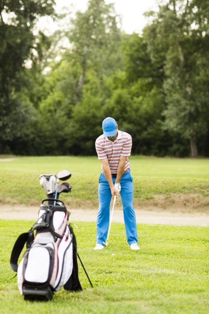 Young man playing golf on the golf course