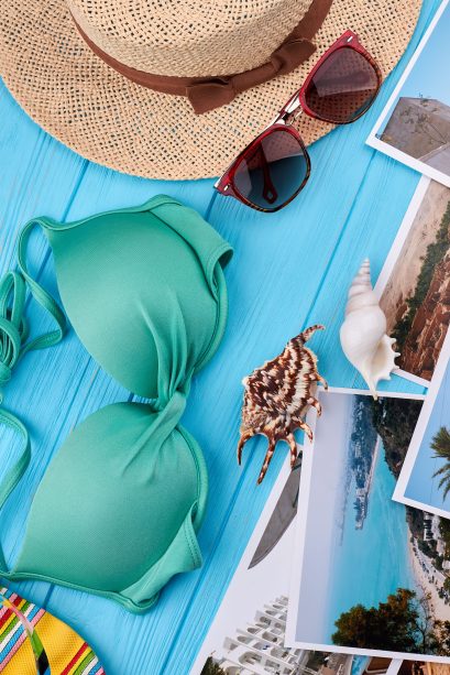 Personal woman clothing for beach. Seashells, photos, blue background. Concept of marine rest.